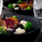 Pork chops are served along side a silky Jerusalem artichoke puree with a cider and blackberry sauce on this perfect late summer early autumn dish.
