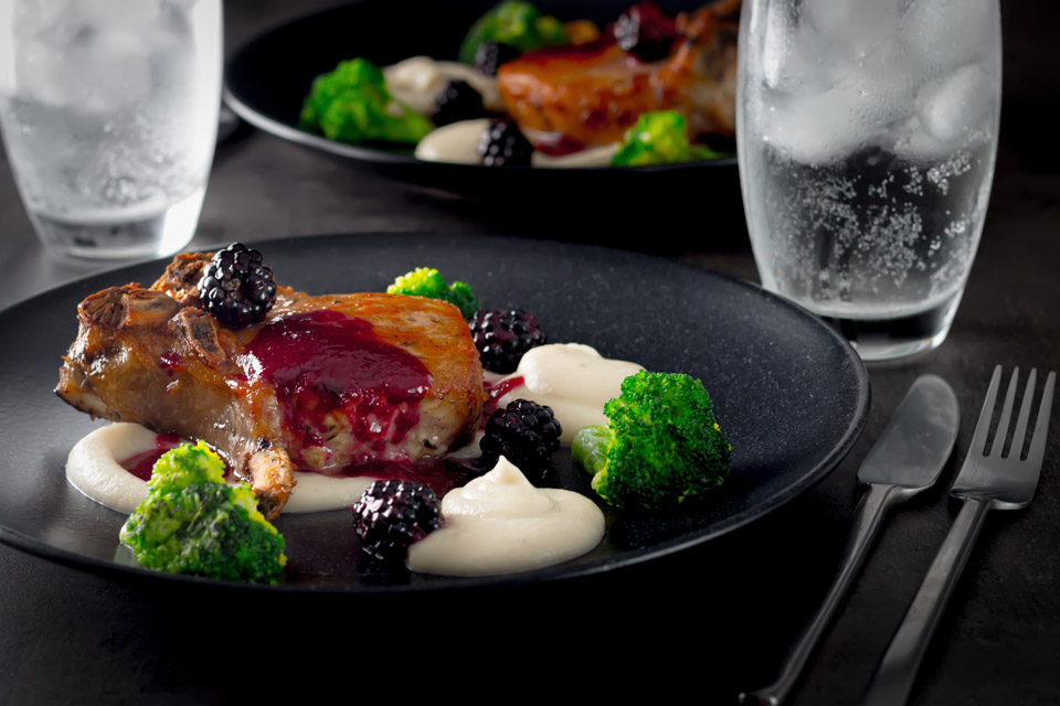 Pork chops are served along side a silky Jerusalem artichoke puree with a cider and blackberry sauce on this perfect late summer early autumn dish.