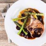 Simply pan fried pork chops are served with a simple potato rosti, some balsamic cherries and asparagus for an old school but delightful meal!