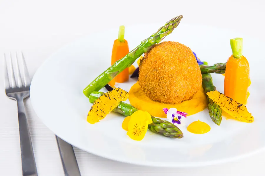 These confit duck leg bonbons are at the centre of a surprisingly light and wonderfully fancy meal featuring an orange and cumin puree and asparagus.