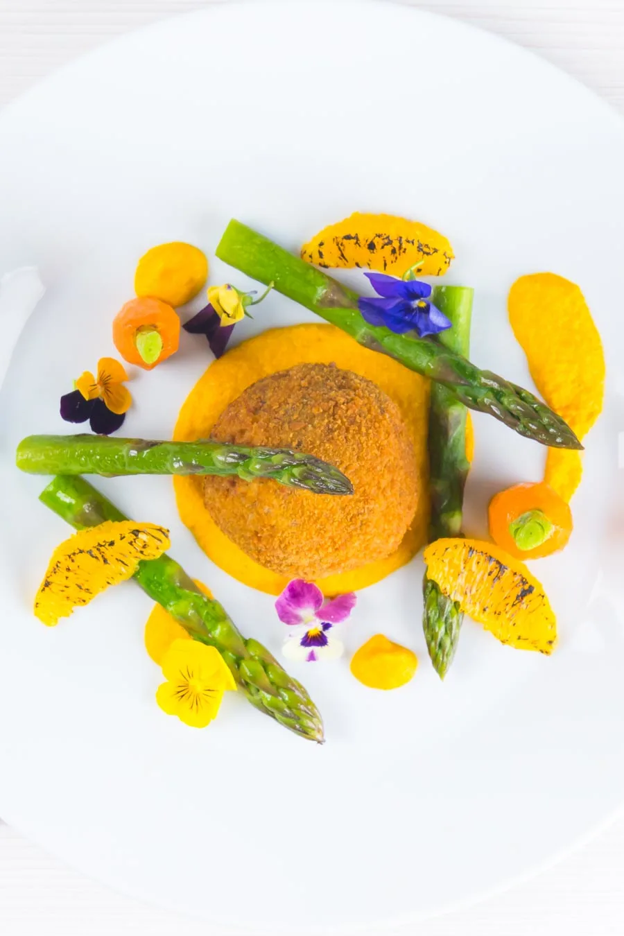 These confit duck leg bonbons are at the centre of a surprisingly light and wonderfully fancy meal featuring an orange and cumin puree and asparagus.