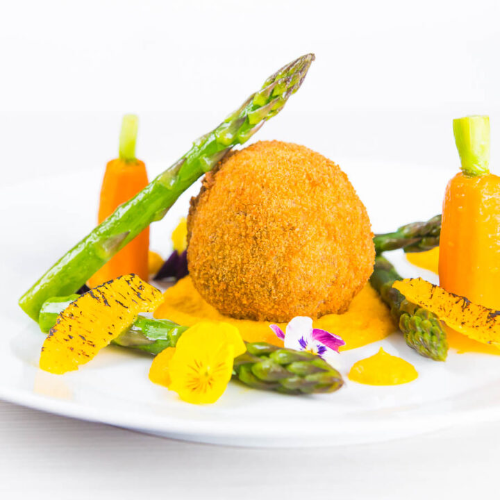 These confit duck leg bonbons are at the centre of a surprisingly light and wonderfully fancy meal featuring an orange and cumin puree and asparagus.