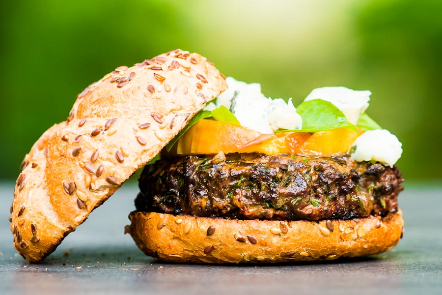 Venison Burger With Peaches And Blue Cheese You can't beat a good grilled burger, but there is life beyond beef. This venison burger is topped with gin cooked peaches and blue cheese!