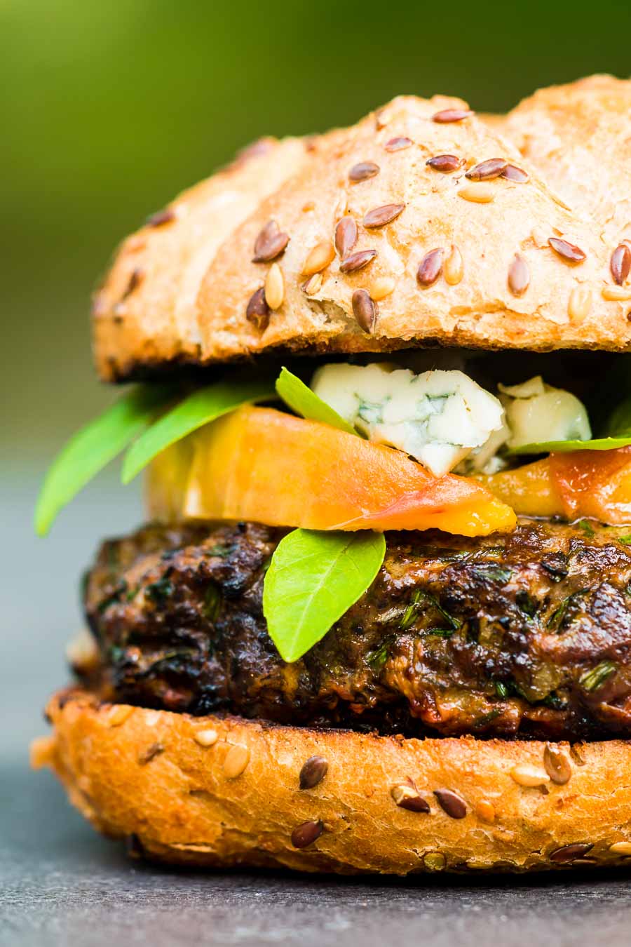 Venison Burger With Peaches And Blue Cheese You can't beat a good grilled burger, but there is life beyond beef. This venison burger is topped with gin cooked peaches and blue cheese!