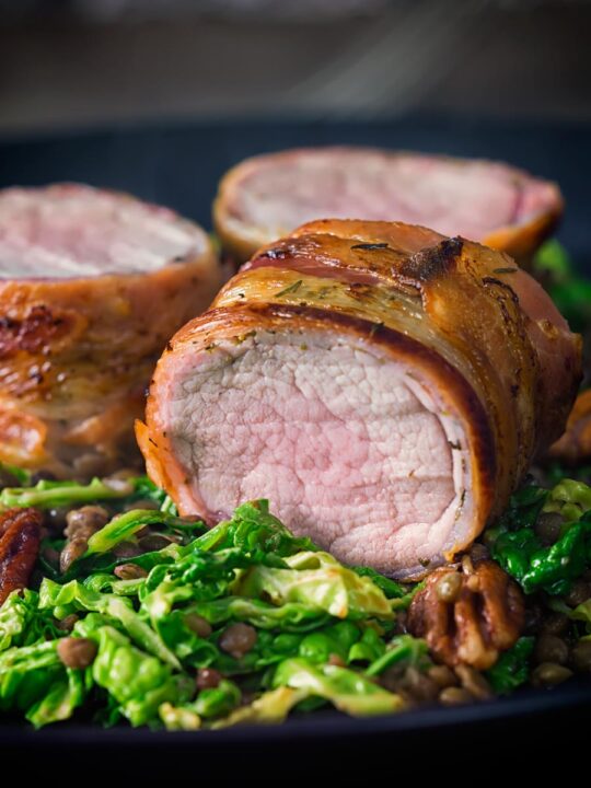 This simple bacon wrapped pork tenderloin recipe is served with a fantastic lentil, pecan nut and cabbage side dish dressed with a mustard dressing.