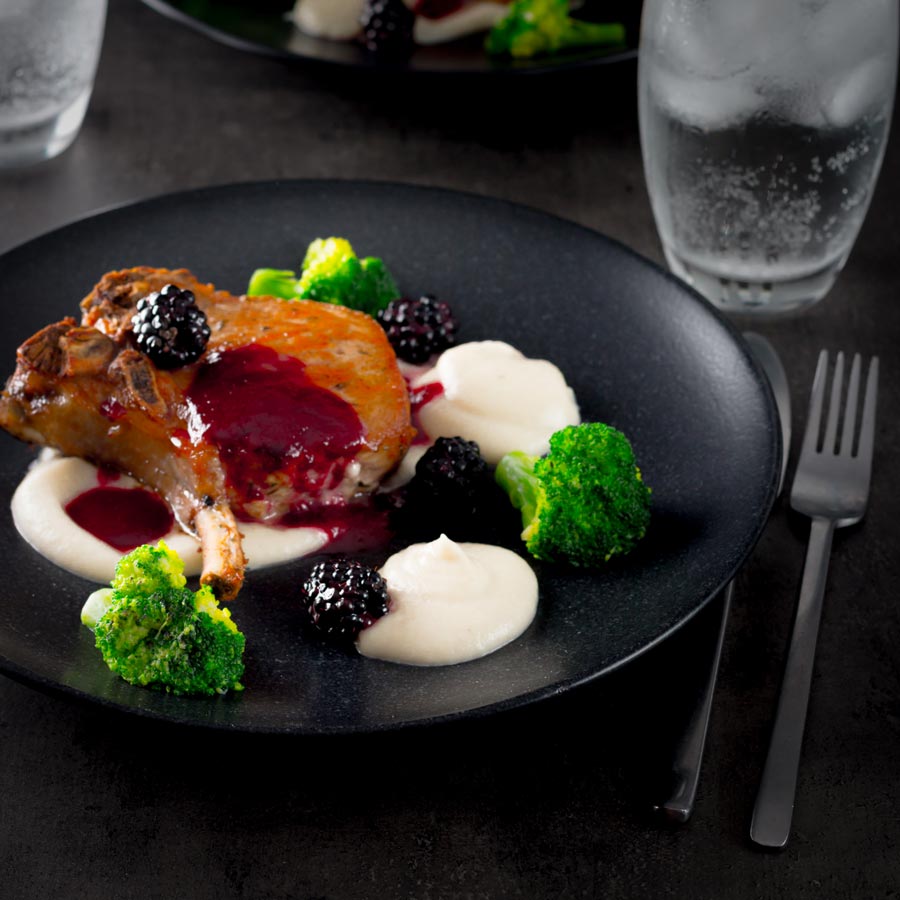 Pork chops are served along side a silky Jerusalem artichoke puree with a cider and blackberry sauce on this perfect late summer early autumn dish.