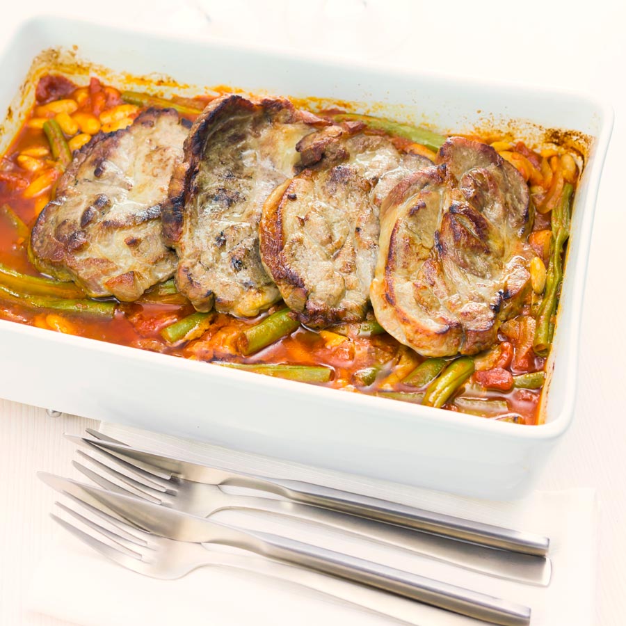 Roast pork chops are always fab and these boneless pork blade or Boston butt chops are roasted on a bed of green beans and white beans in a tomato sauce.