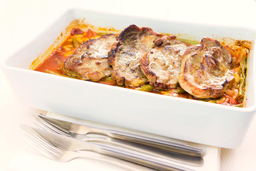 Roast pork chops are always fab and these boneless pork blade or Boston butt chops are roasted on a bed of green beans and white beans in a tomato sauce.