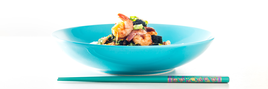 Teriyaki Shrimp with broccoli served in a blue bowl with chopsticks set against a bright white background.