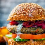 Portrait close up image of an Indian inspired spicy lamb burger with a red onion chutney