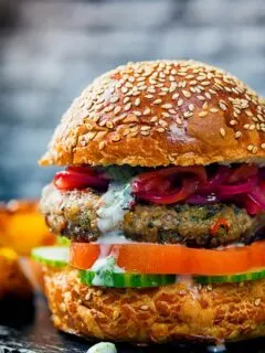 Portrait close up image of an Indian inspired spicy lamb burger with a red onion chutney