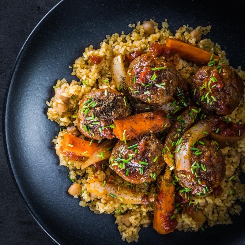The bed of Harissa spiked bulgur wheat and chickpeas is the perfect bed for these Moroccan inspired beef meatballs, a wonderful winter warmer!