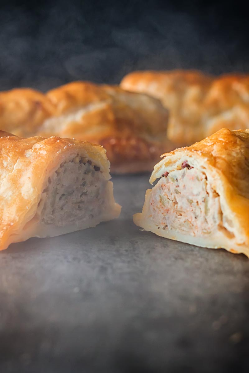 Tall close up image of the interior of a sliced shortcrust pastry wrapped sausage roll