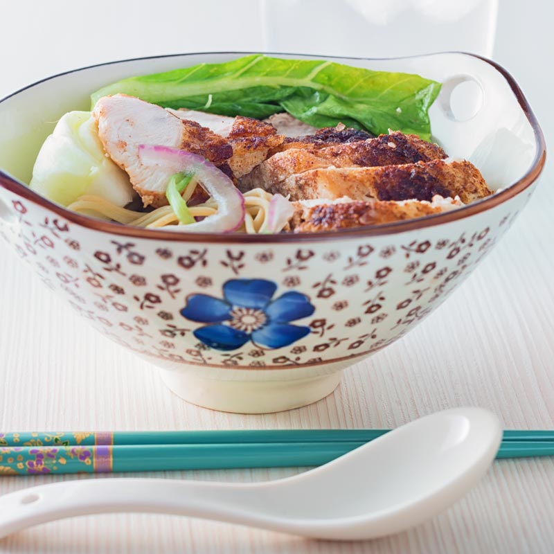 Square image of a Chinese chicken noodle soup in an Chinese style bowl with a blue flower