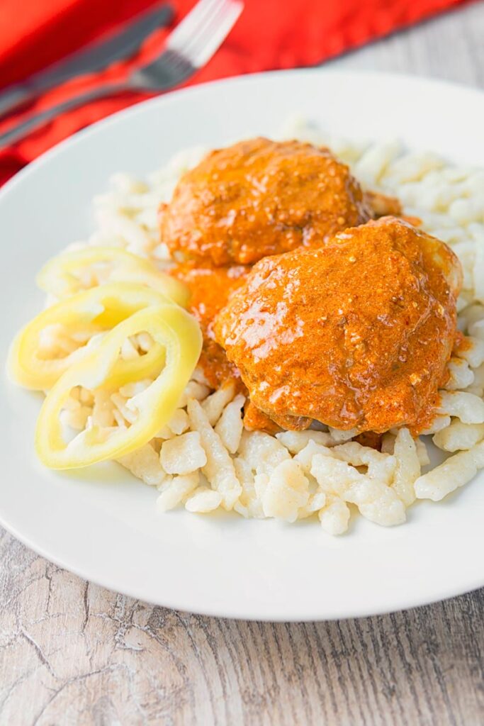 Hungarian Chicken Paprikash with Homemade Nokedli, moist chicken thighs in a velvety sweet paprika rich sauce served with fresh nokedli or dumplings