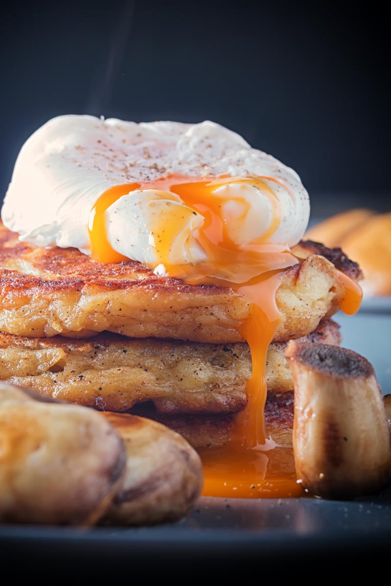 Stacked Irish Boxty pancakes with a perfectly poached eggwith a dripping golden egg yolk