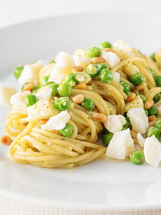 Pesto spaghetti is given a new breath of life with some peas, goats cheese and some extra pine nuts, to make a quick pasta dinner.
