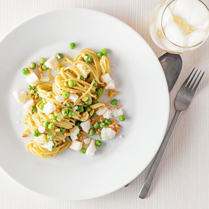 Pesto spaghetti is given a new breath of life with some peas, goats cheese and some extra pine nuts, to make a quick pasta dinner.
