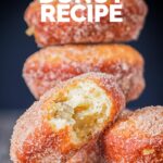 Portrait Image of cinnamon sugar coated donuts with a bite out of one cooked from a basic donut recipe with text