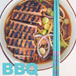 Overhead portrait image of a spicy pork ramen noodle soup served in a bowl with turquoise chopsticks with text