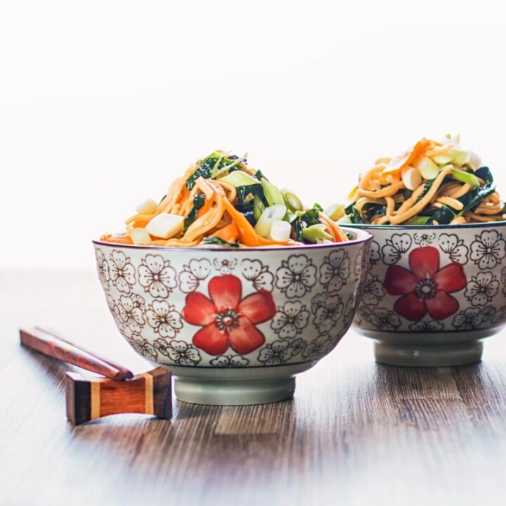 Square image of two bowls with Asian patterns and chopsticks containing sweet and sour Stir Fried Noodles