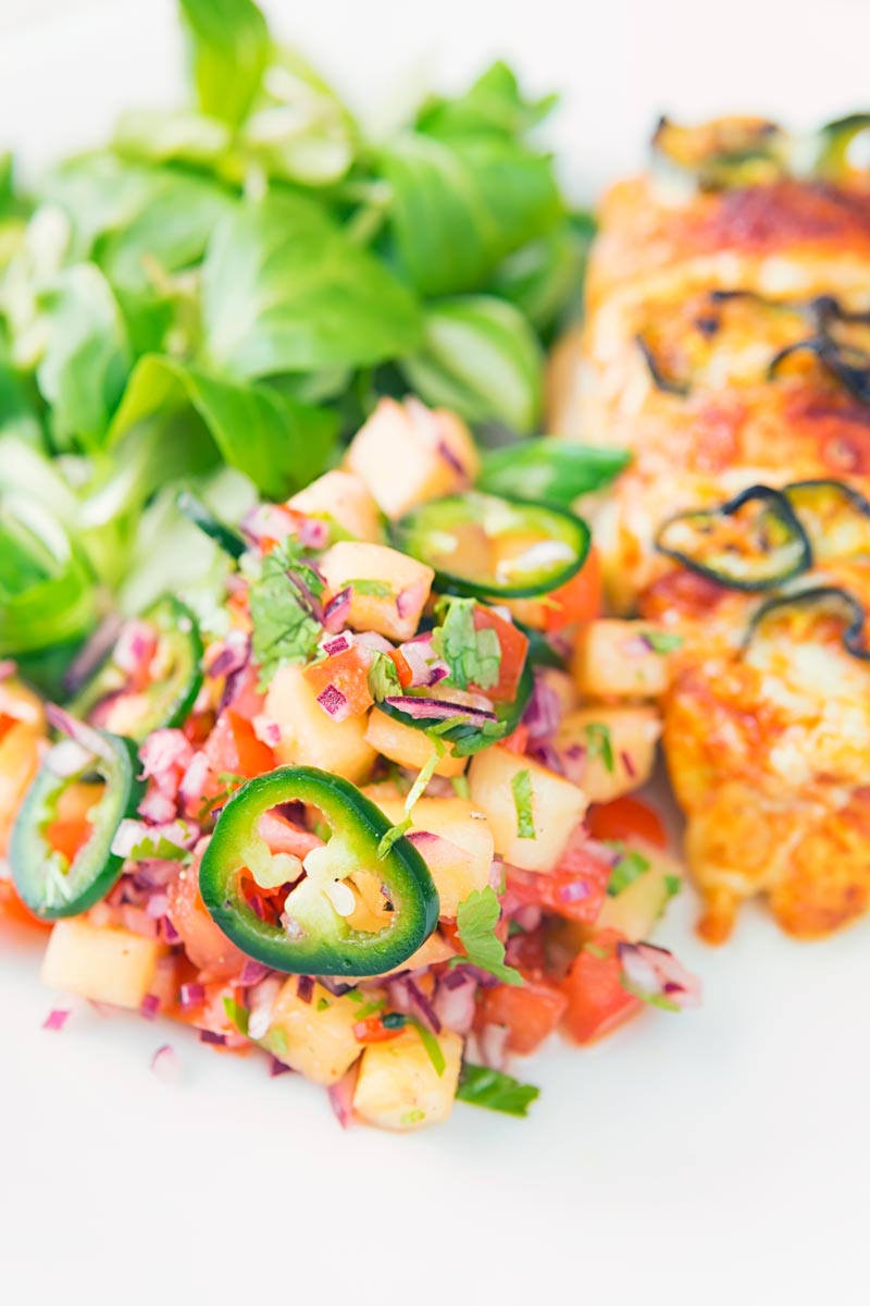 Close up portrait image pineapple salsa served with a green salad and stuffed chicken breast