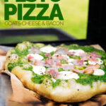 Portrait image of a Rocket Pesto Pizza with goats cheese and bacon cooked on a BBQ with text