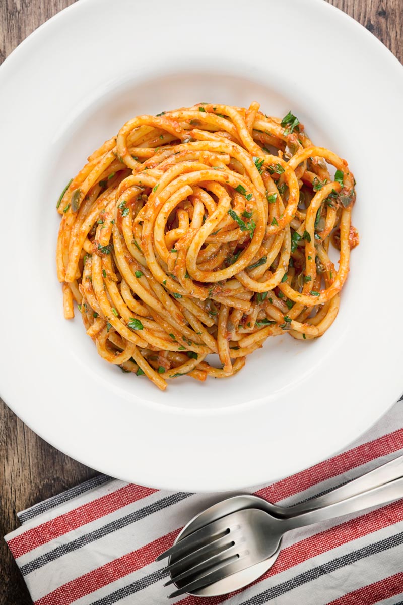 Portrait overhead image of Bucatini pasta in a tomato sauce