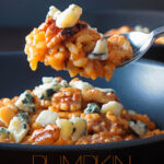 Portrait close up image of a pureed pumpkin risotto with blue cheese and walnuts served in a black bowl with spoon taking a portion with text overlay