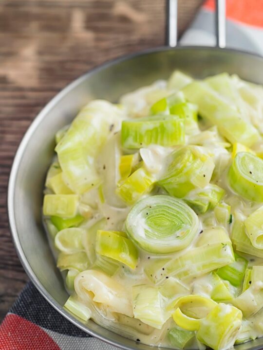 Portrait image of classic creamed leeks served in a pan