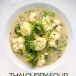 Portrait overhead image of a green Thai curry soup with cauliflower and broccoli served in a white bowl with text overlay