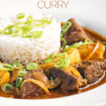 Portrait close up image of a Thai beef massaman curry served with jasmine rice in a white bowl with text overlay
