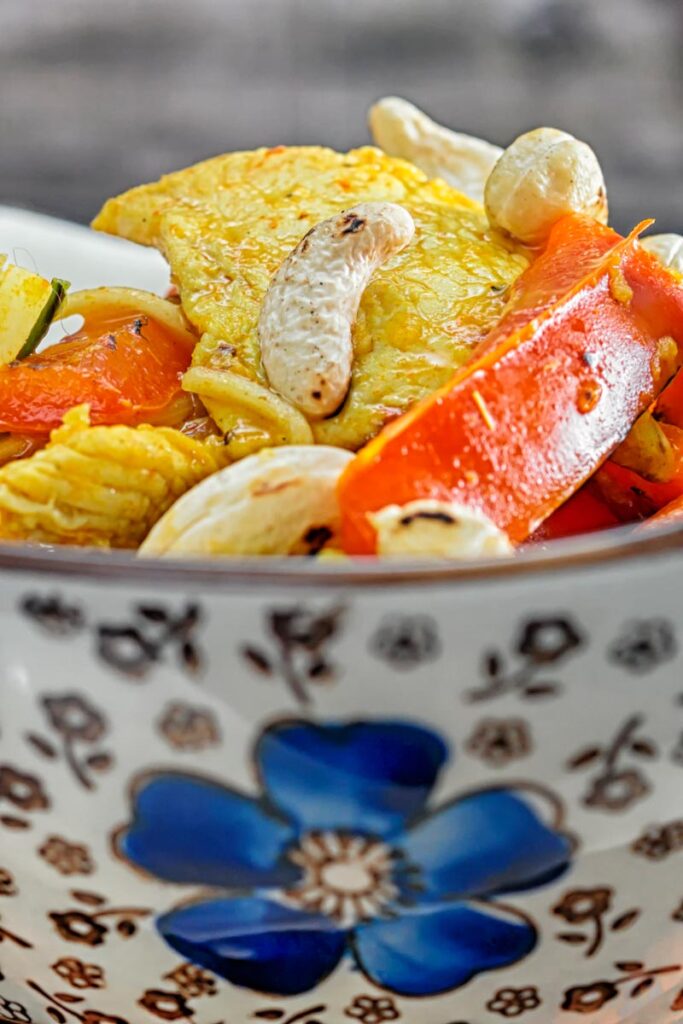 Portrait Close up image of chicken curry noodles served in an Asian style bowl decorated with a blue flower