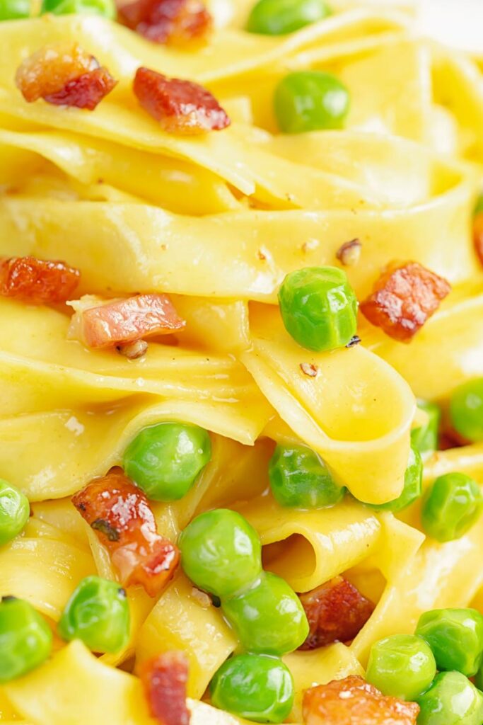 Portrait close up image of pasta carbonara with peas