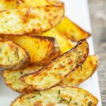 Portrait image of potato wedges served on a white plate
