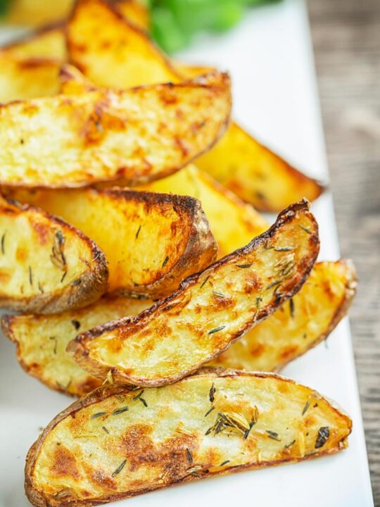 Oven baked potato wedges served on a white plate