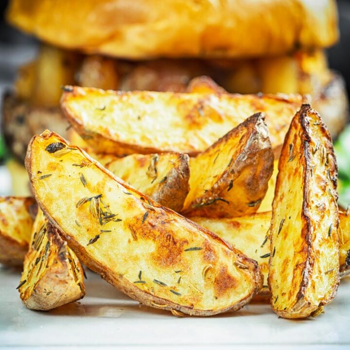 Square close up image of potato wedges served on a white plate