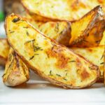 Portrait close up image of potato wedges served on a white plate