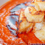 Portrait close up image of a tower of toasted croutons served with roast tomato soup and a swirl of balsamic reduction with text overlay