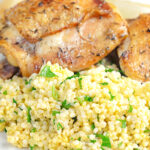 Portrait image of toasted millet served on a white plate with chicken thighs with text