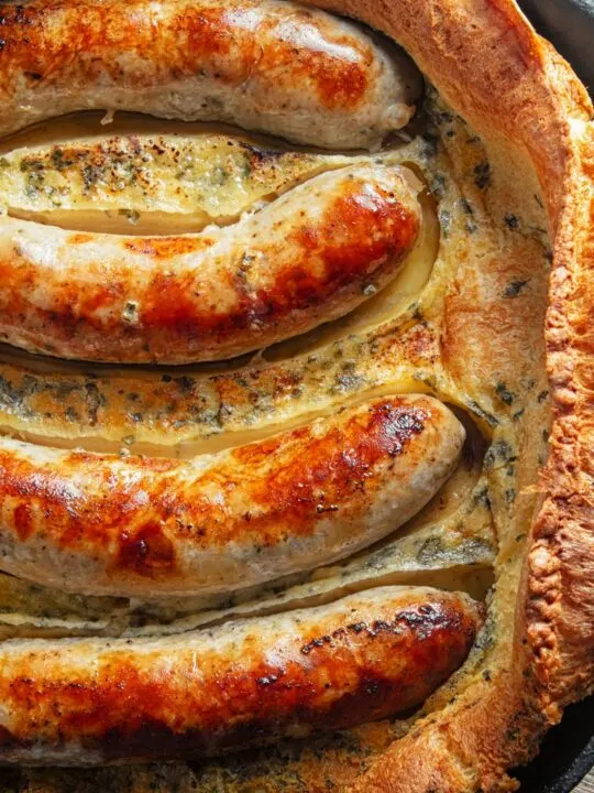Portrait close up overhead image of toad in the hole, or sausages cooked in a Yorkshire pudding batter