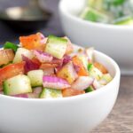Portrait image of an Indian kachumber side salad served in a white bowl