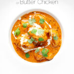 Portrait overhead image of murgh makhani or a butter chicken curry with a swirl of cream and fresh coriander served in a white bowl with text overlay