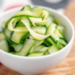 Portrait image of quick pickled cucumber ribbons served in a white bowl