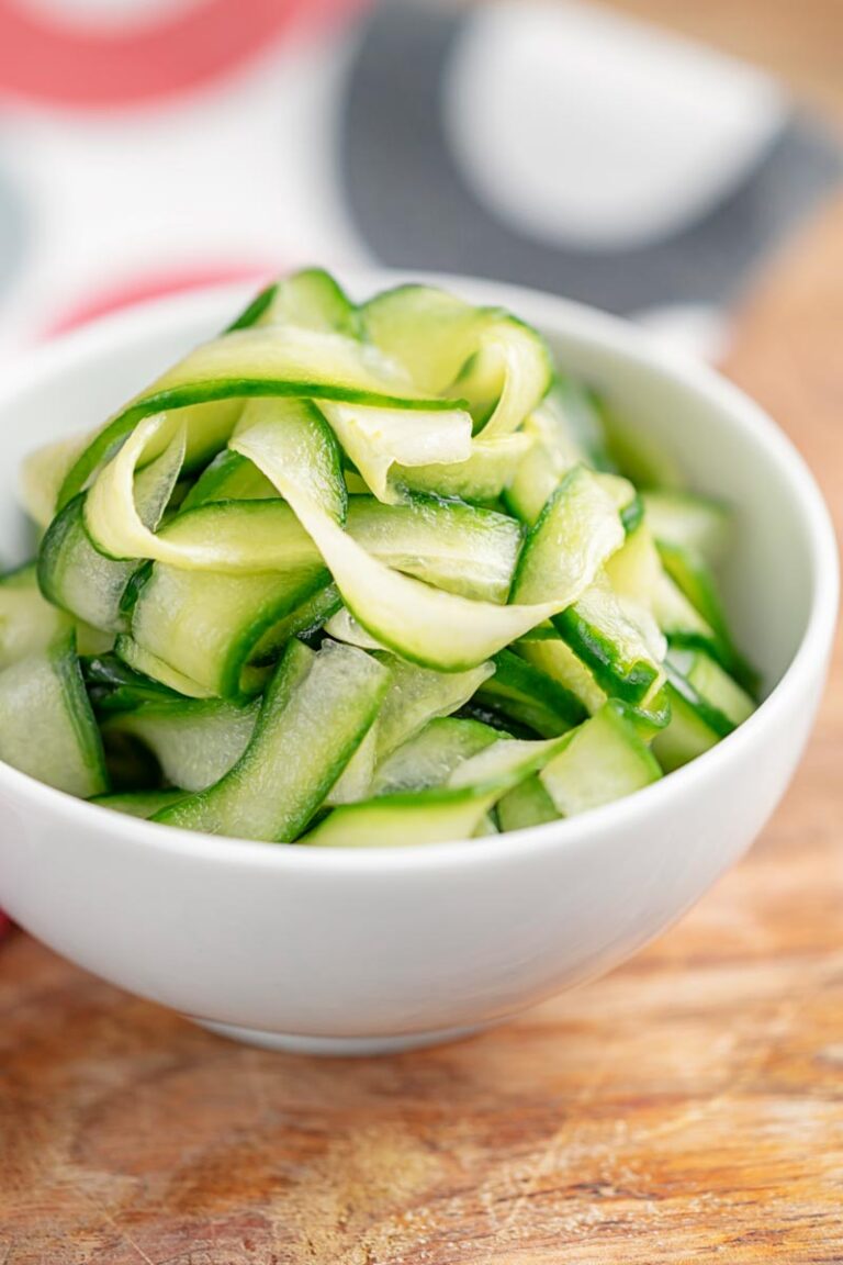Portrait image of quick pickled cucumber ribbons served in a white bowl