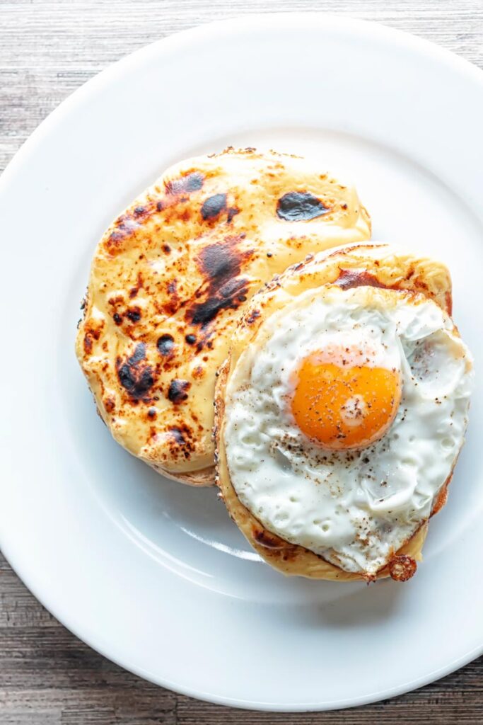 Portrait overhead image of welsh rarebit with a fried egg, AKA buck rarebit served on a white plate