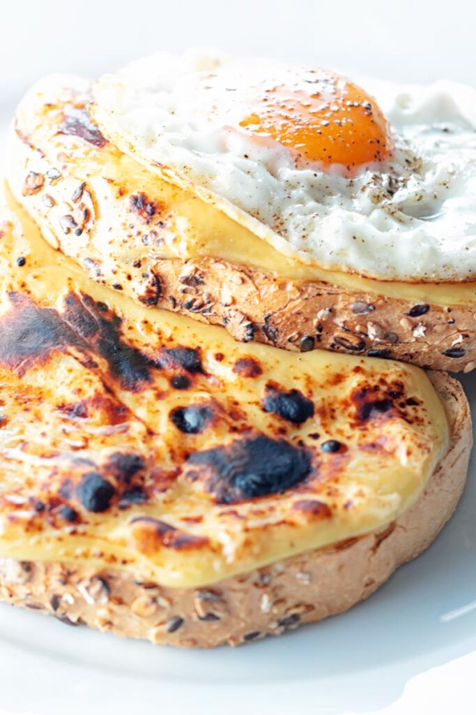Portrait image of welsh rarebit with a fried egg, AKA buck rarebit served on a white plate