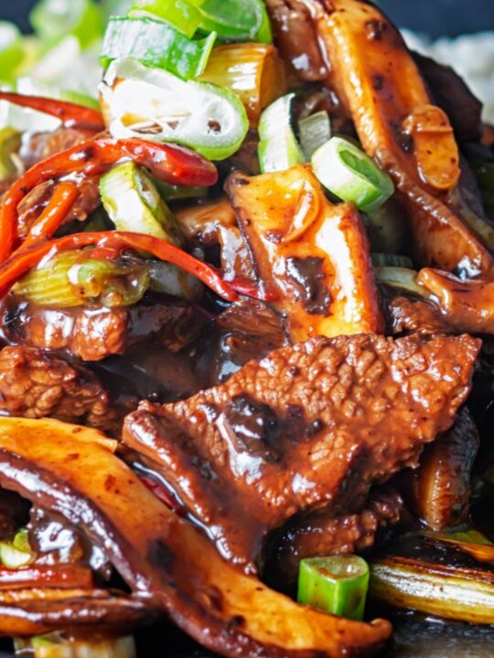 Portrait close up image of a streaming hot Chinese beef and shiitake mushroom stir fry