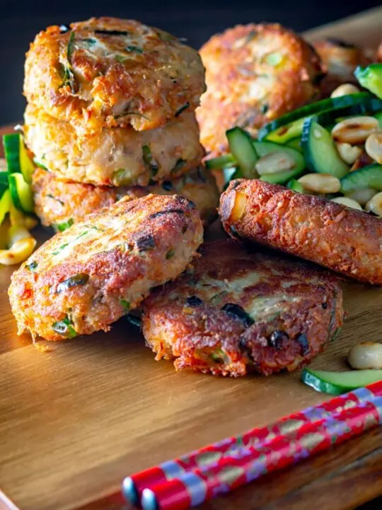 Portrait image of spicy Thai tuna fish cakes served with a cucumber and peanut salad