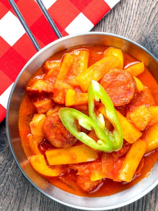 Portrait overhead image of a Hungarian Lecso, a tomato and pepper stew with salami and bacon